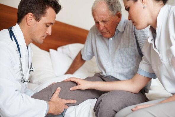 The doctor examining a patient's knee